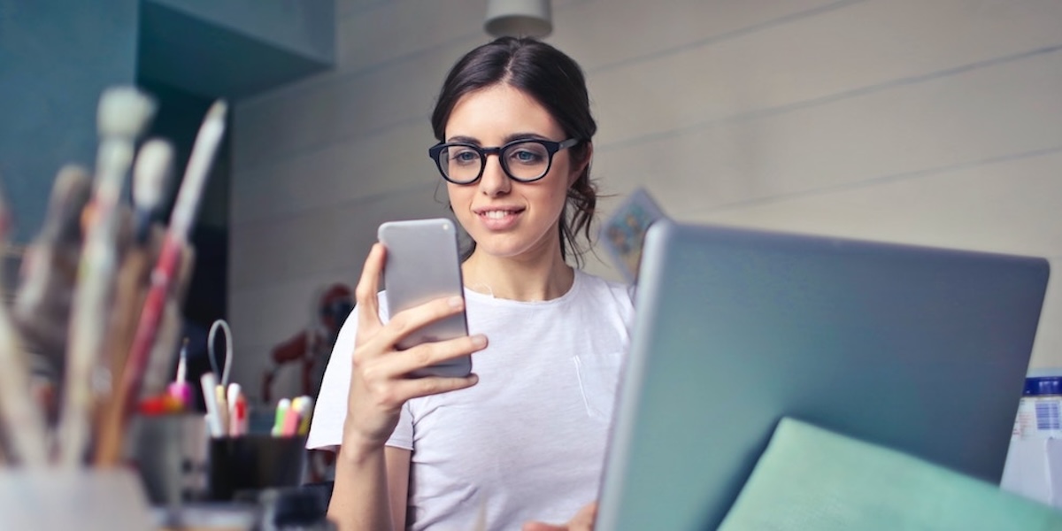 Girl behind desk with iPhone