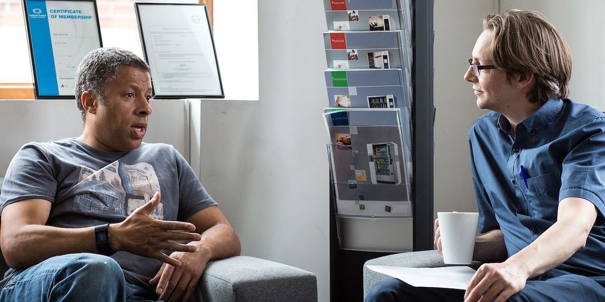 Two men talking while one is listening.