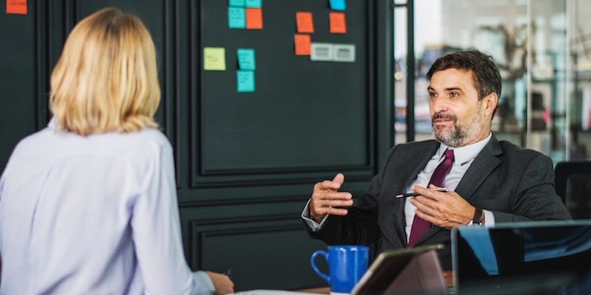 Two people talking over a desk