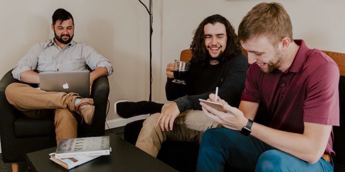 Three men collaborating with laptops