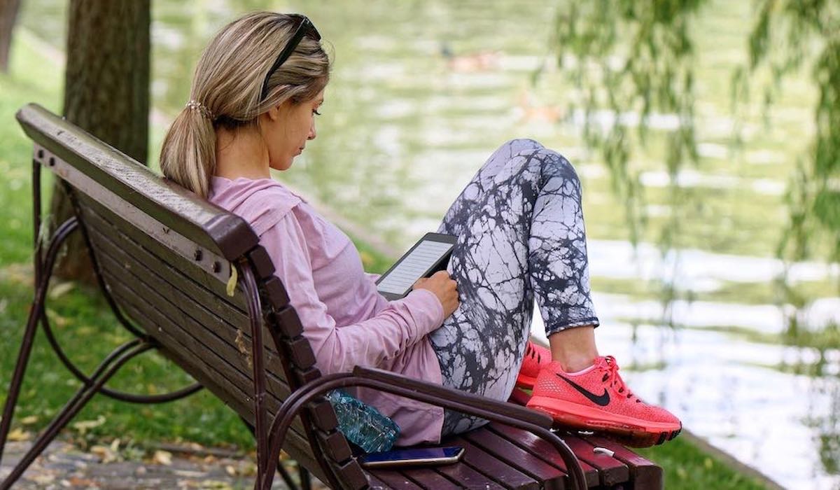 Woman engaged in reading on her tablet.
